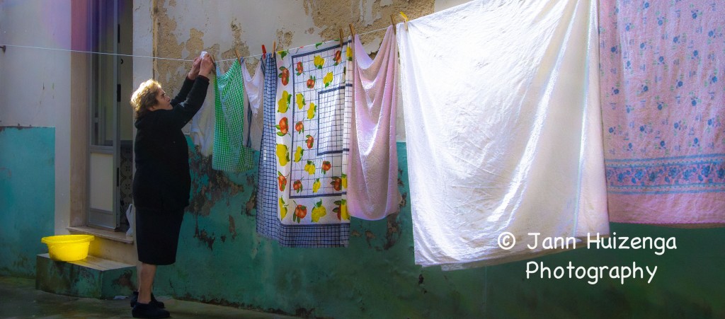Sicilian woman hanging laundry, copyright Jann Huizenga